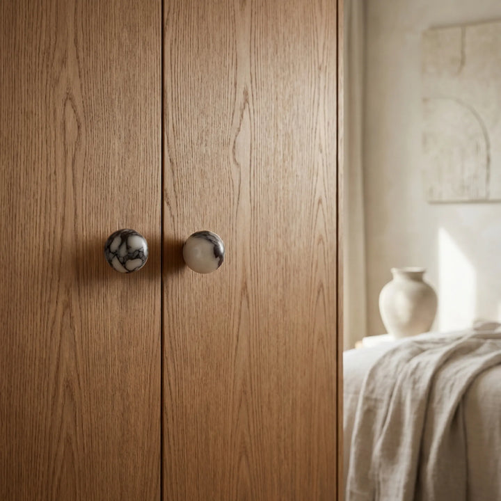 pair of round bulgari marble cupboard knobs on tall oak closet doors.