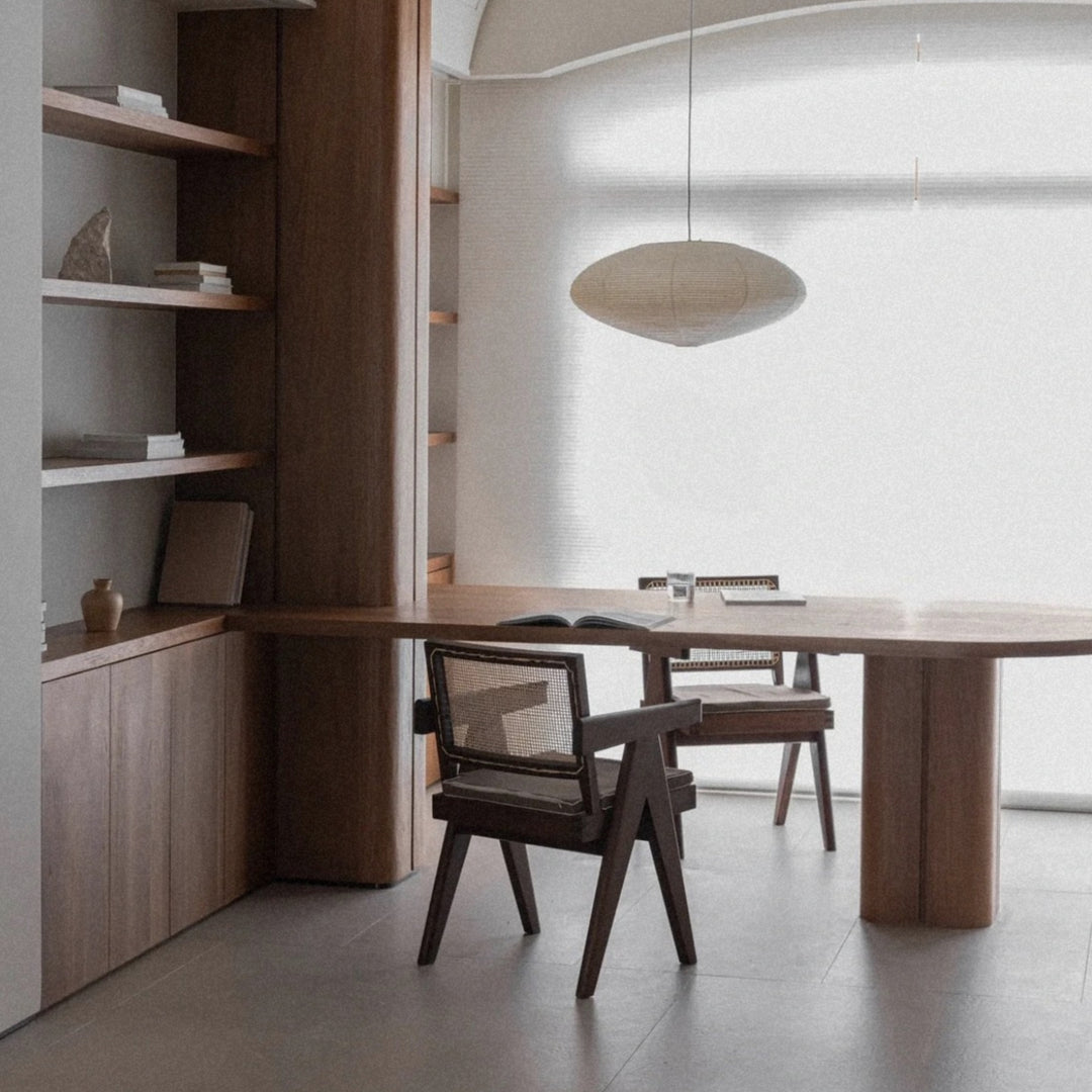 paper lantern style pendant light suspended above a dining table in a calm modern room.
