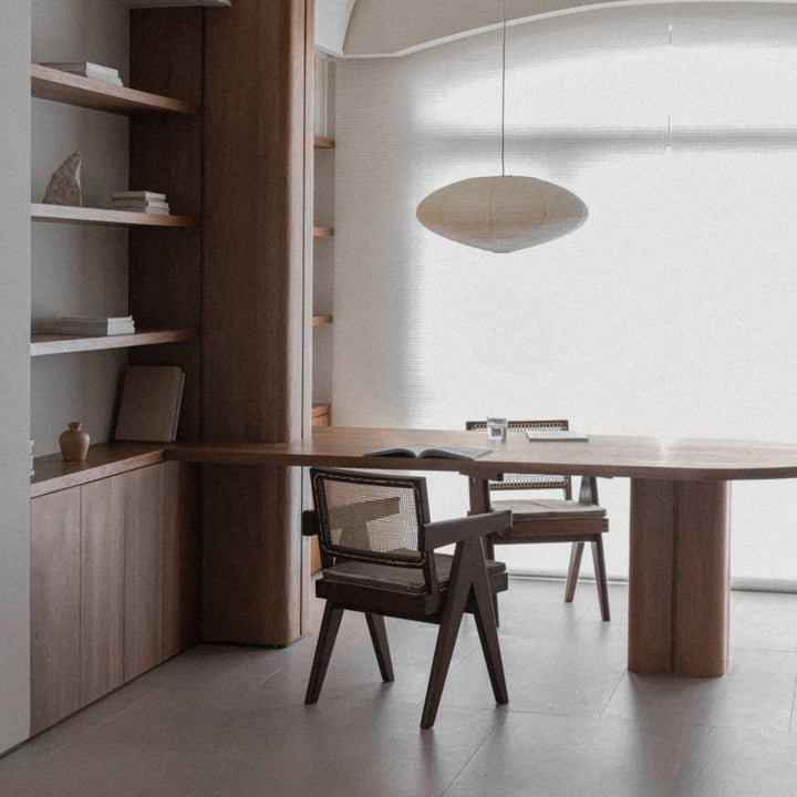 paper lantern style pendant light suspended above a dining table in a calm modern room.