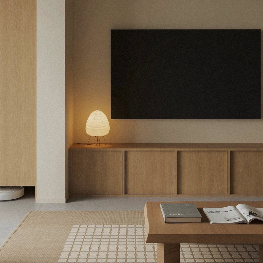 paper lantern style table lamp placed on a console cabinet beneath a wall mounted television.