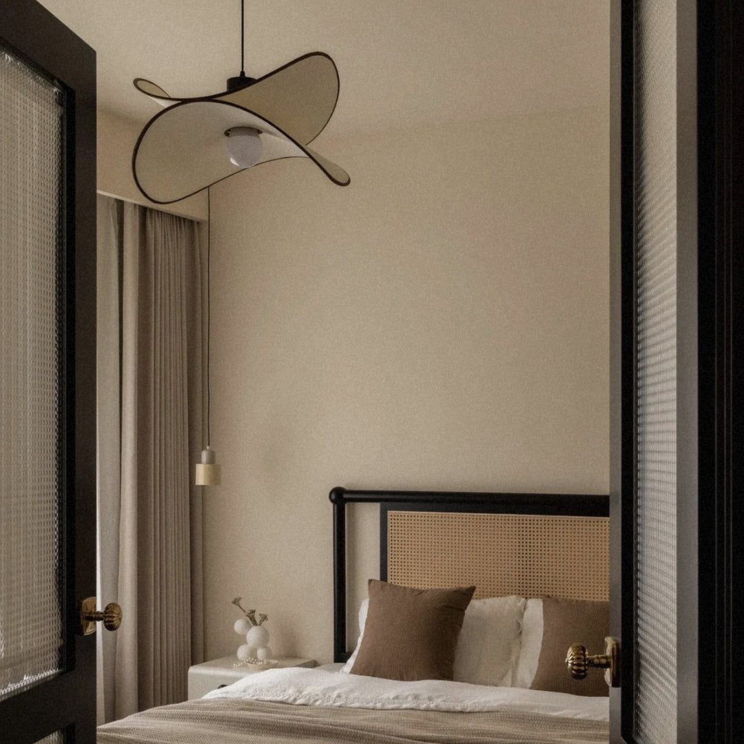 pendant light used as bedroom lighting above a neatly styled bed.