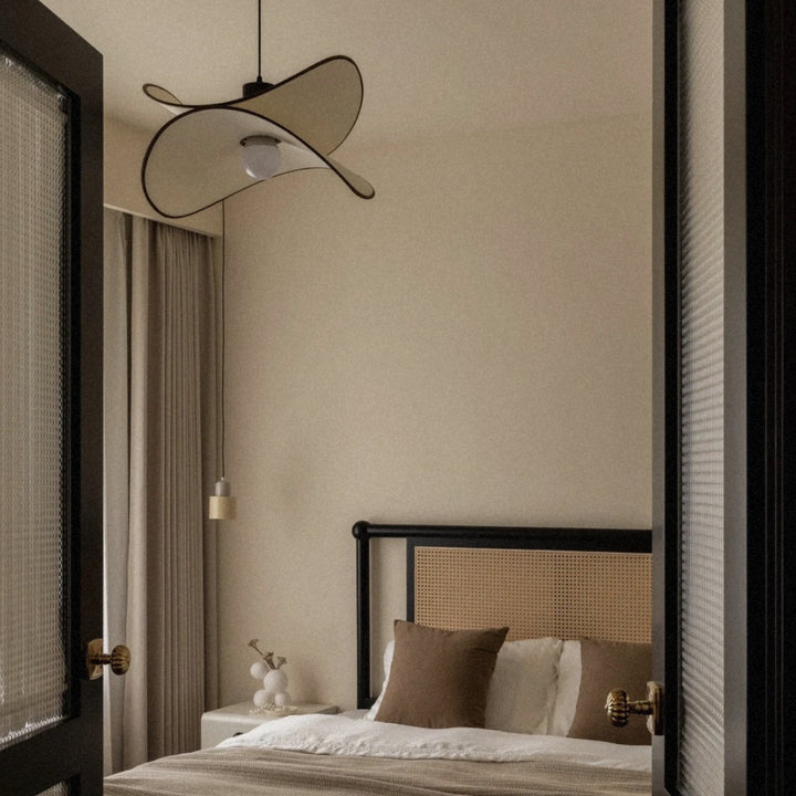 pendant light used as bedroom lighting above a neatly styled bed.