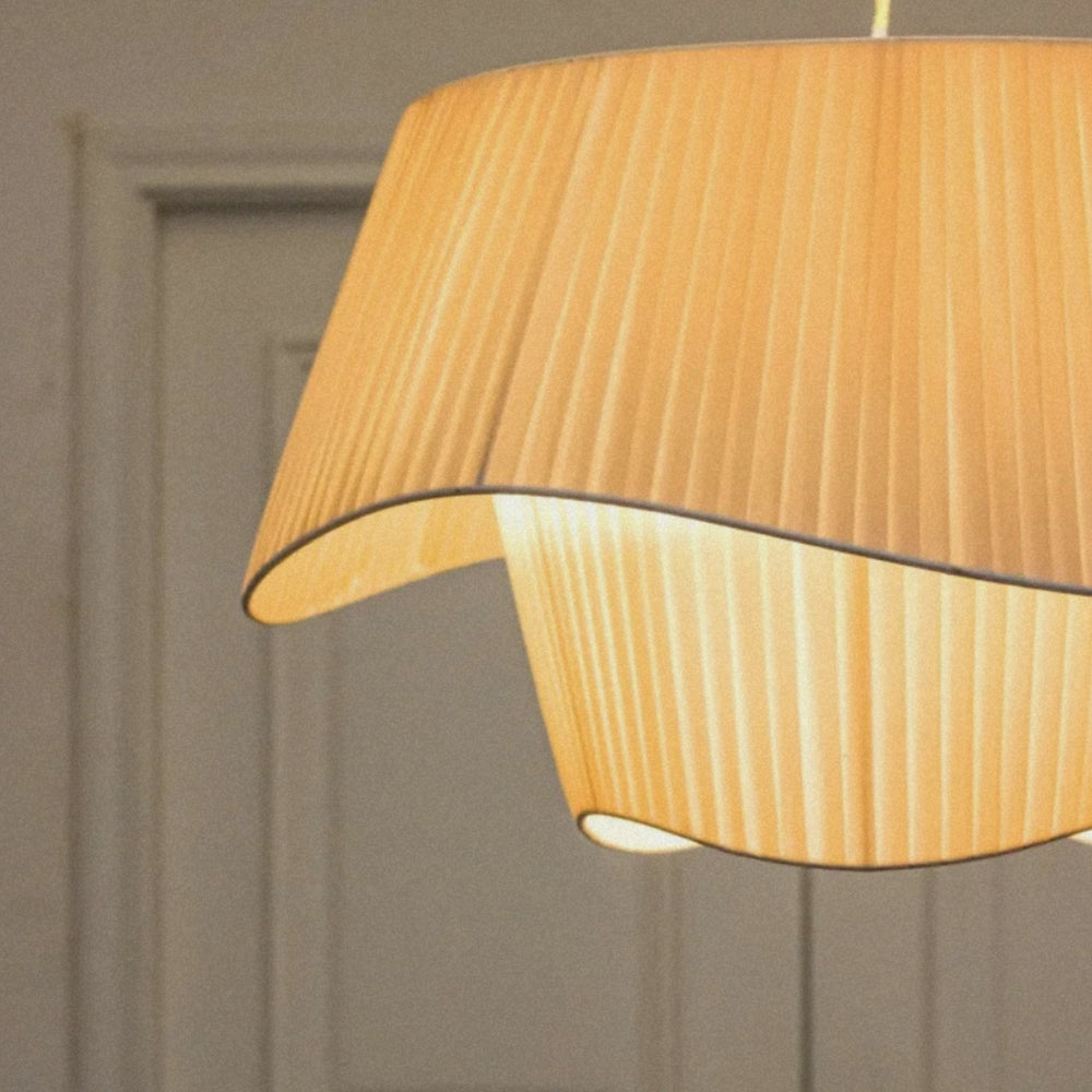 close view of a pleated fabric pendant lamp creating warm diffused lighting.