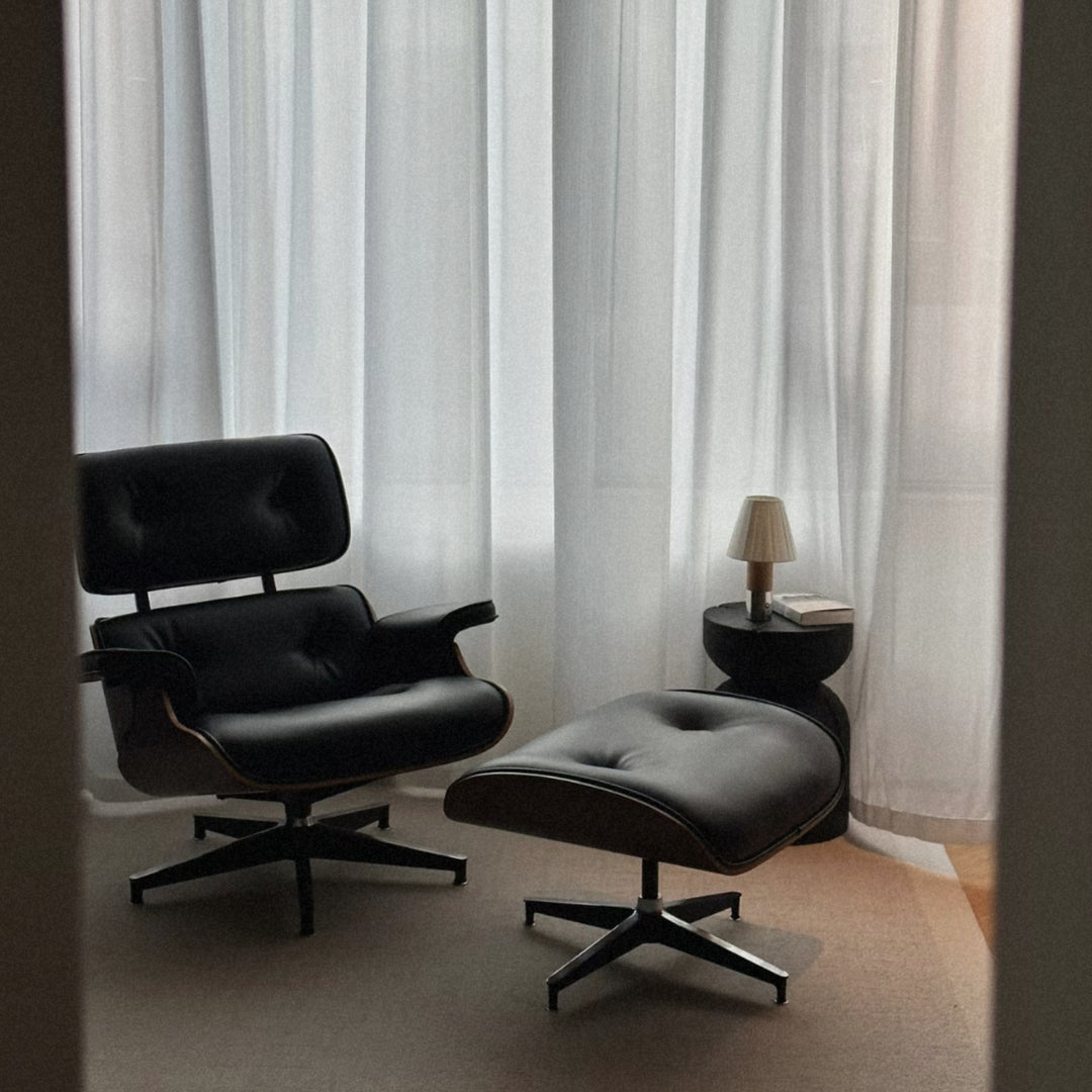 portable lamp positioned on a side table next to a lounge chair.
