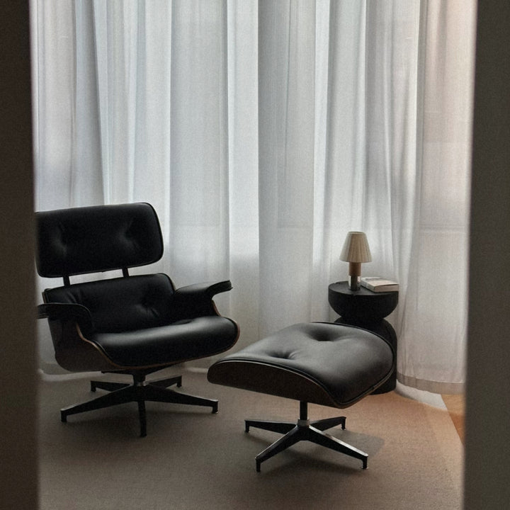 portable lamp positioned on a side table next to a lounge chair.