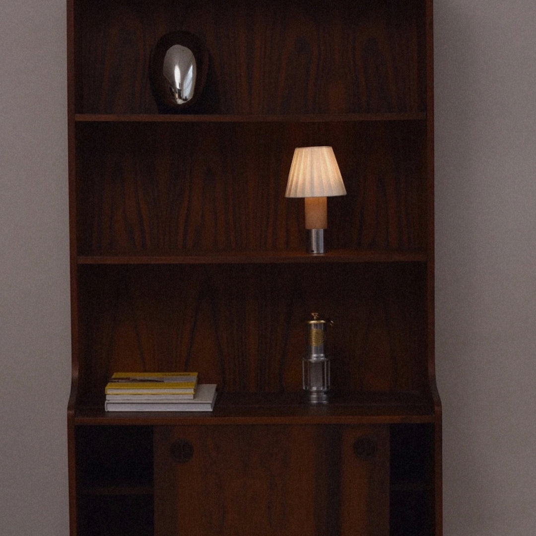 portable lamp placed on a shelf creating a subtle ambient lighting effect.