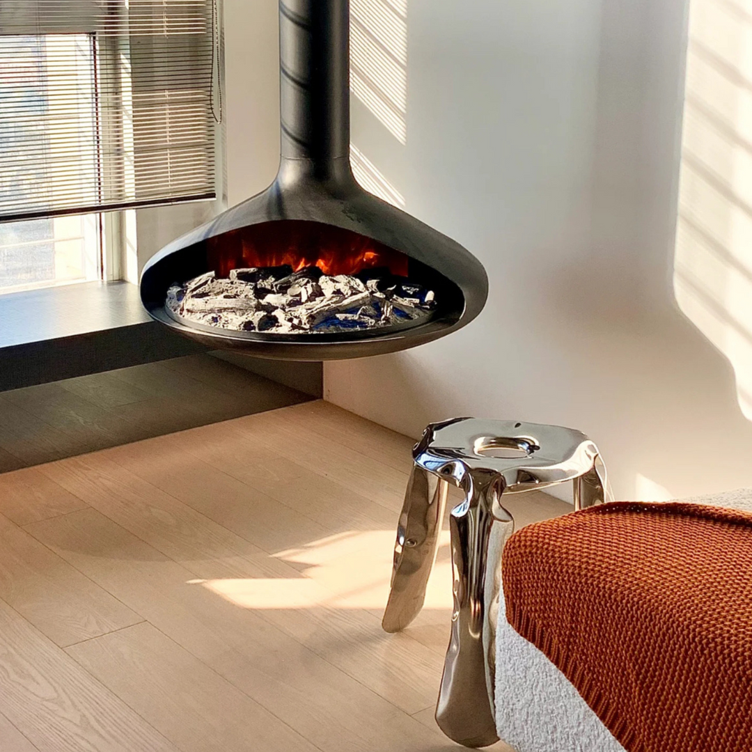 Reflective metal stool catching light in a modern, cozy living room.