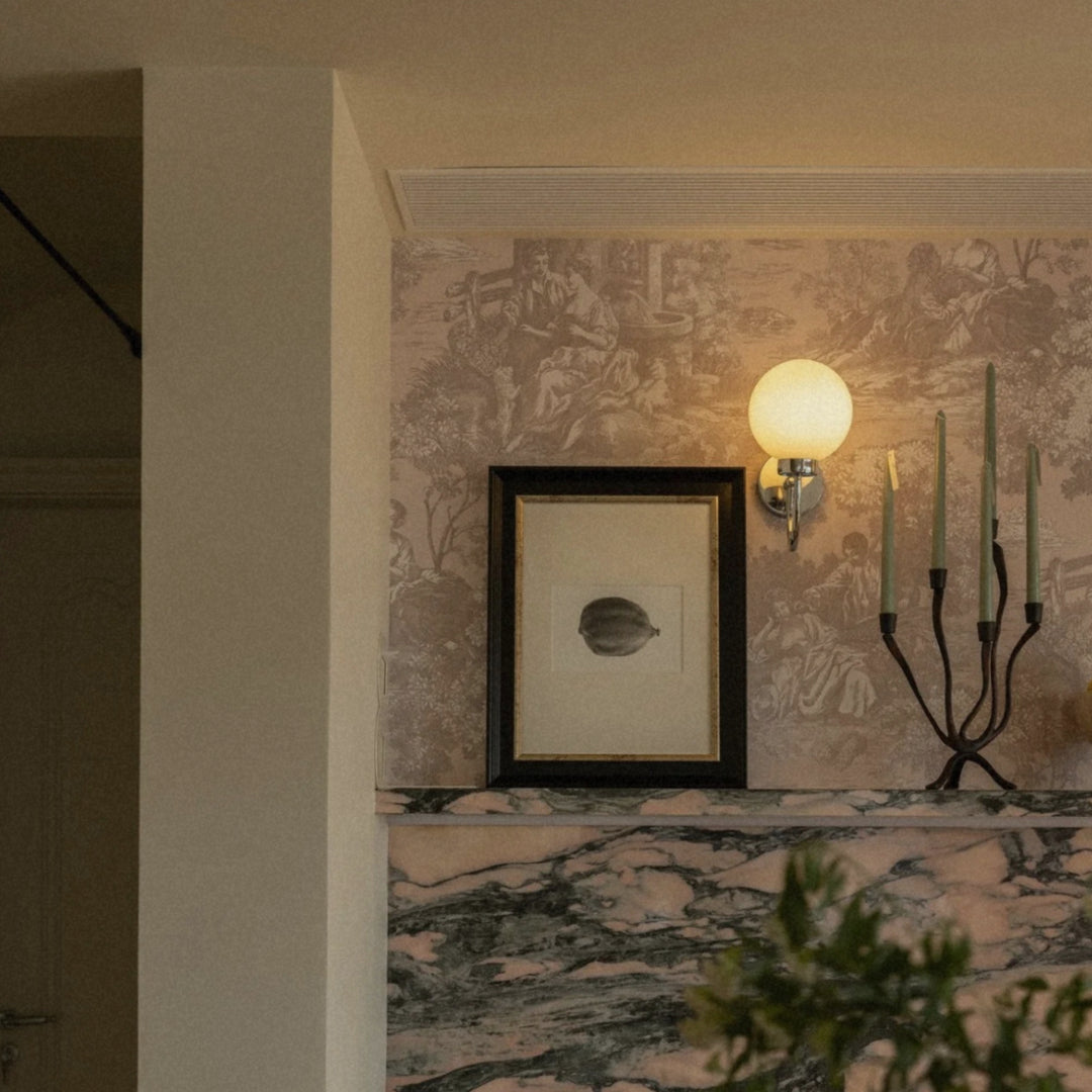 scandinavian-inspired candle holder styled on marble fireplace with moody wall tones