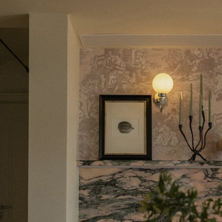 scandinavian-inspired candle holder styled on marble fireplace with moody wall tones