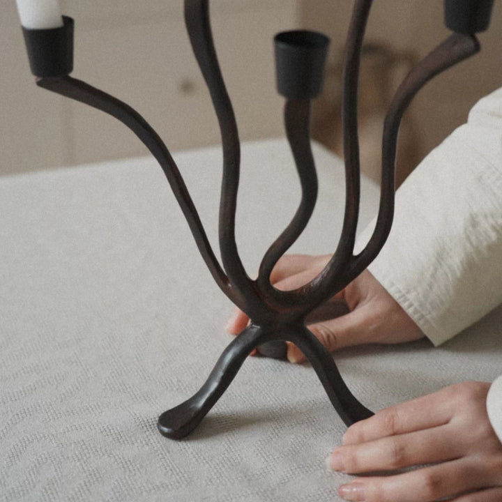 closeup of metal candle holder showing sculptural curves and texture