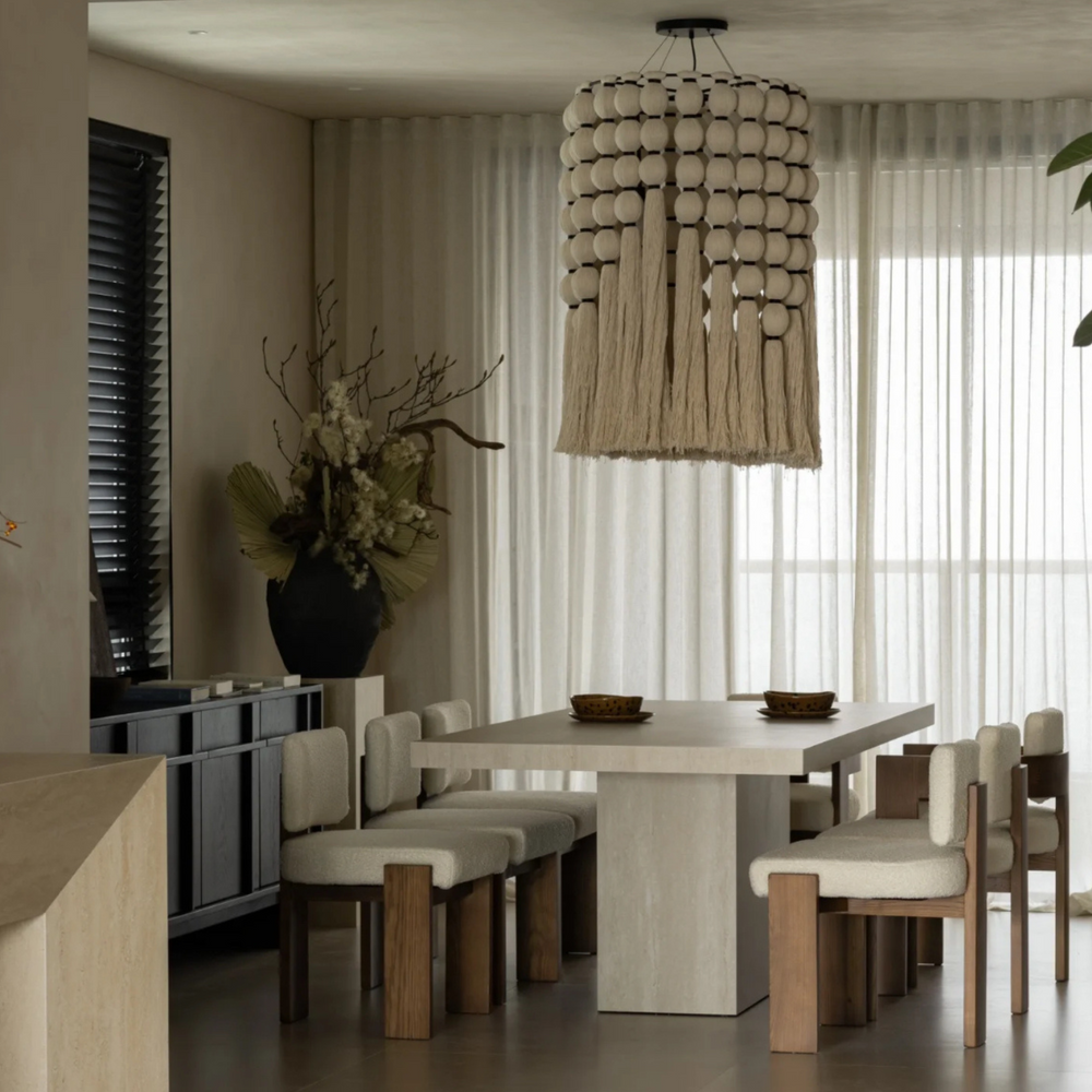 Sculptural ceiling light in organic modern dining space with wood and fabric textures