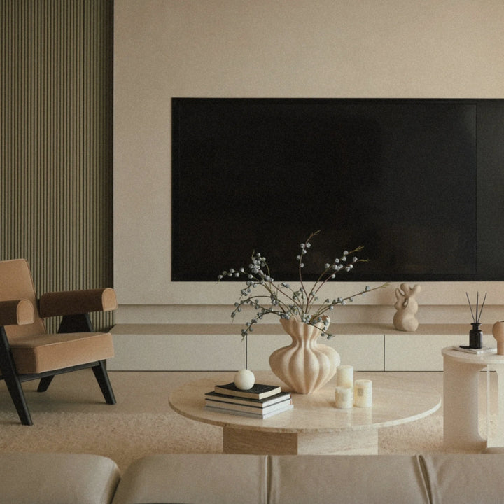 sculptural ceramic vase with organic curves styled on a coffee table in a calm organic modern living room with neutral decor.