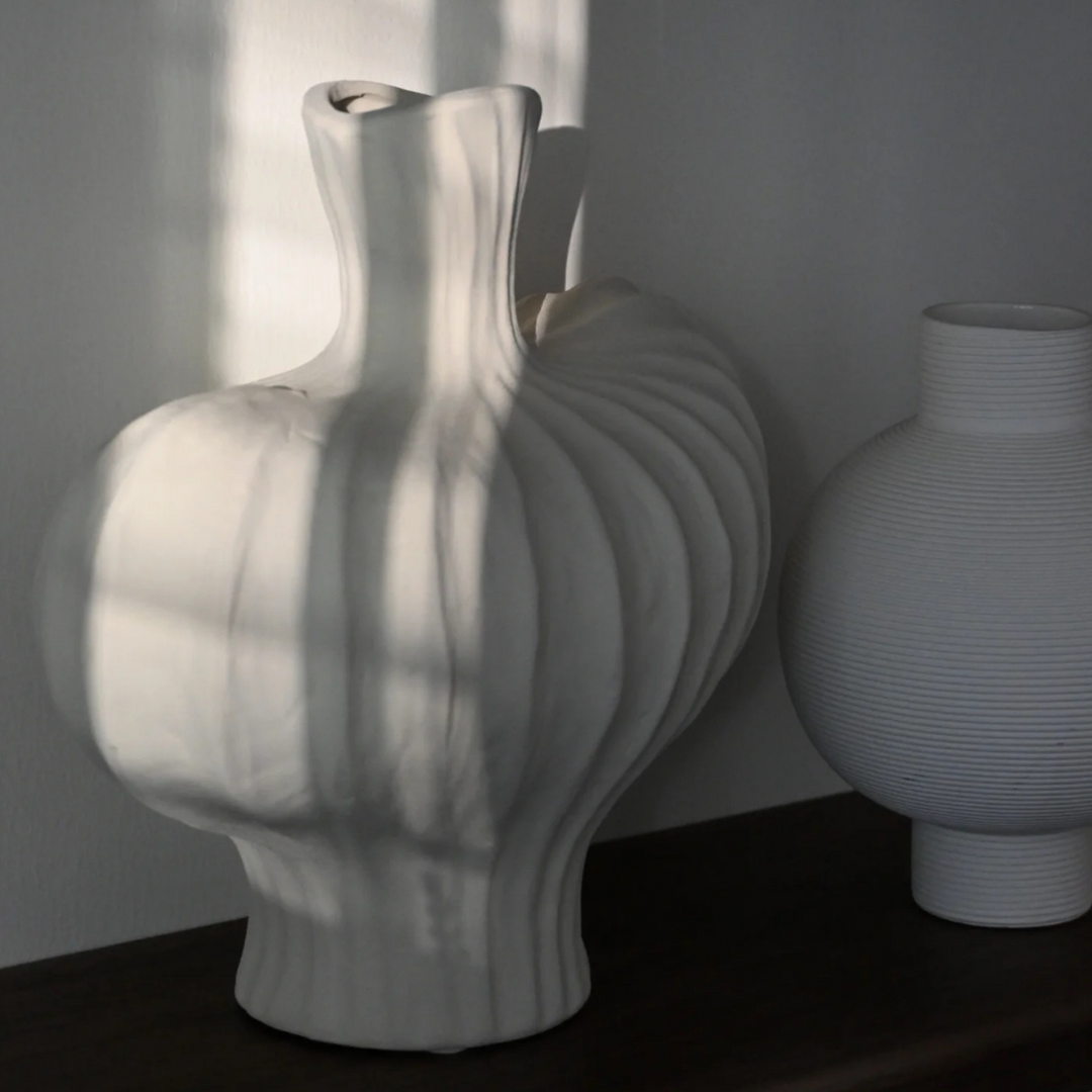 Sculptural cream ceramic vase styled in a minimalist setting, ideal for Scandinavian and contemporary decor.