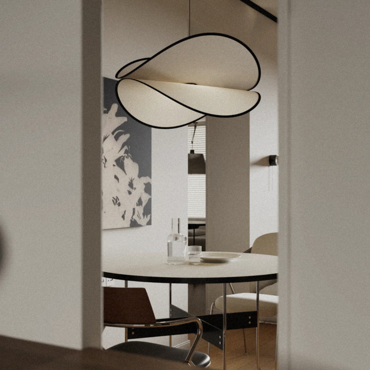 sculptural pendant light positioned above a table in a minimal space.