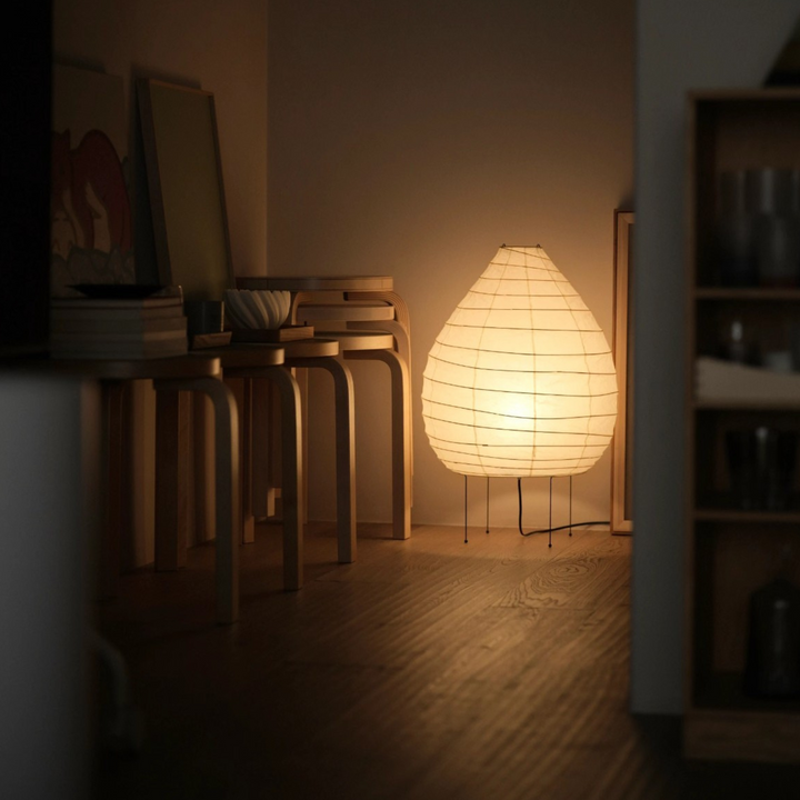 Soft-lit sculptural floor lamp adding warmth to a Japandi-style bedroom corner.