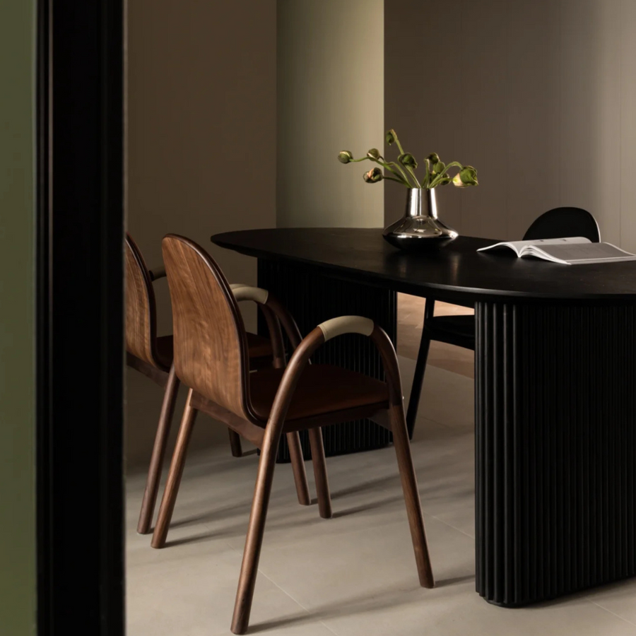 Stainless steel vase with a mirror-polished finish on a black dining table, perfect for minimalist and contemporary decor.