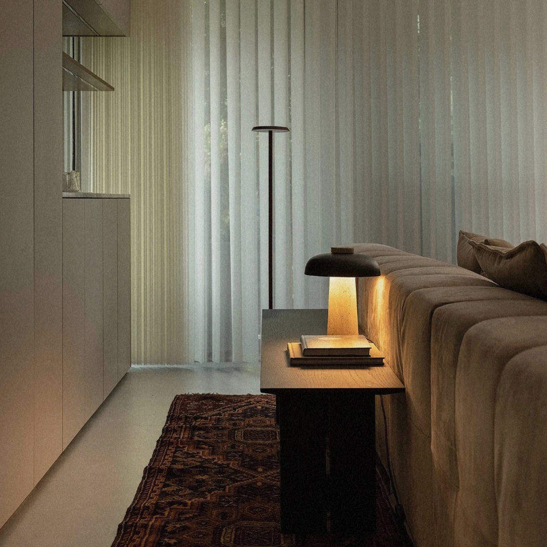 stone table lamp positioned near a sofa adding warm light to a quiet living room corner.