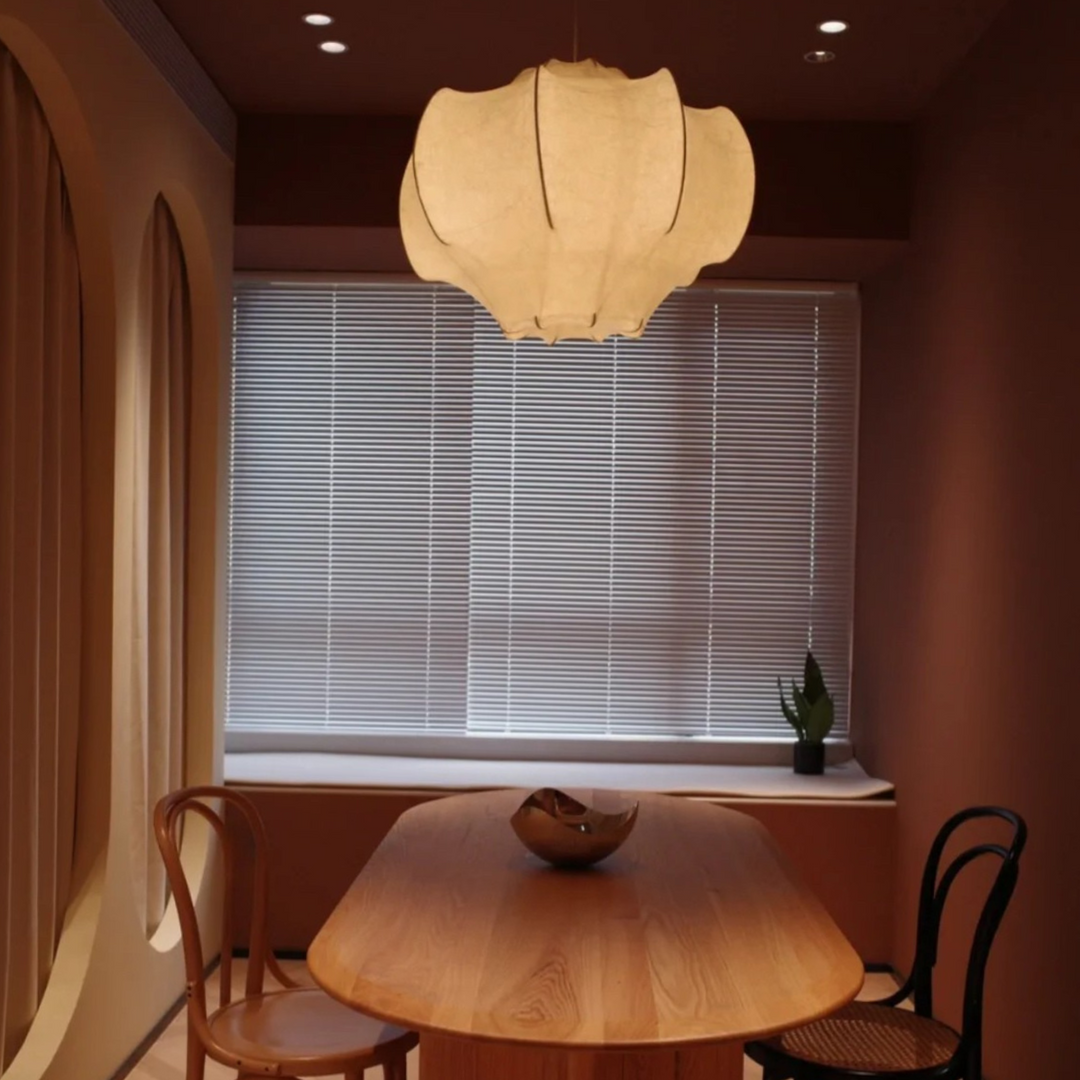 Stylish pendant light over a modern dining setup, blending seamlessly with chic furnishings and warm ambient lighting.