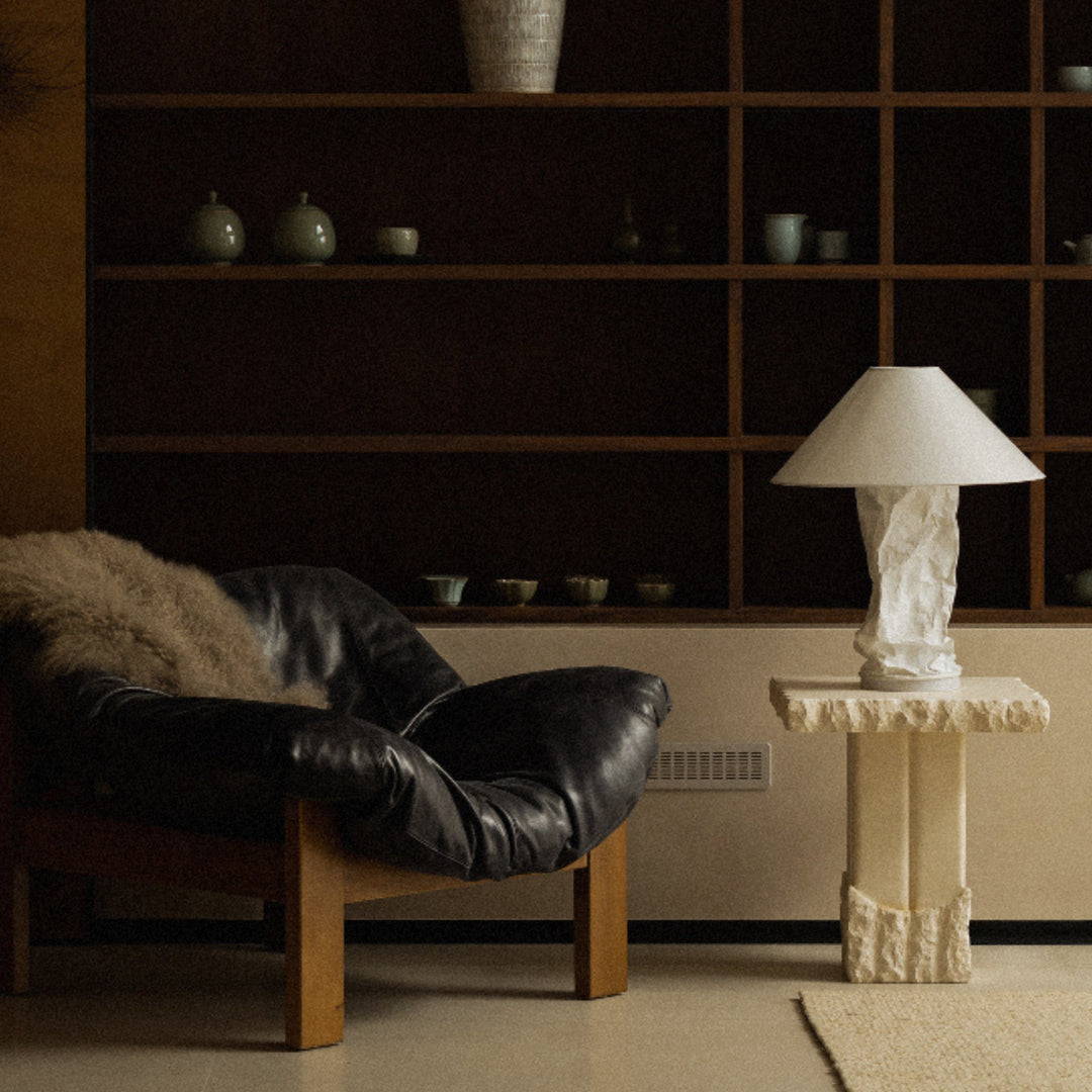 table lamp set on a side table next to a chair in a warm living space.