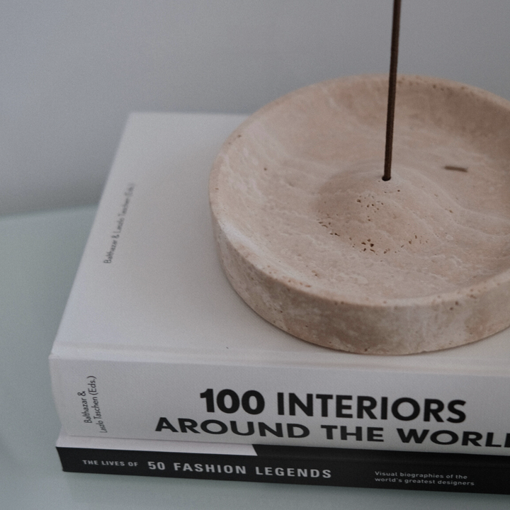 Natural travertine incense holder placed on a design book, perfect for modern minimalist decor.