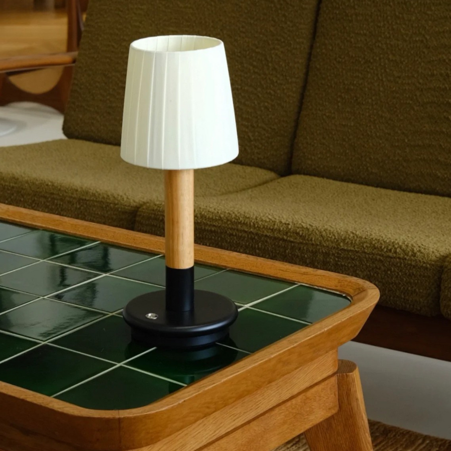 Living room with a vintage-style cordless lamp on a wooden coffee table, adding a classic touch to the modern space.