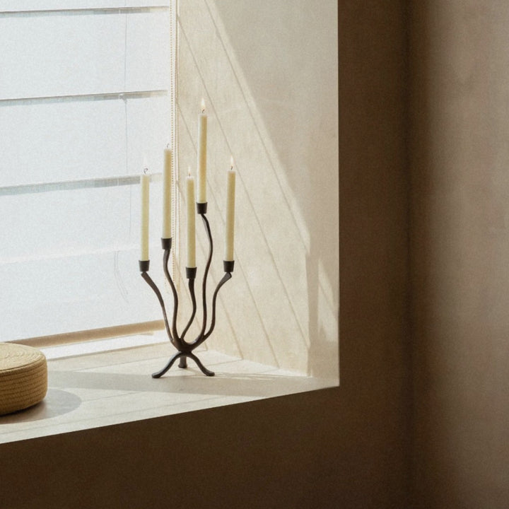 wabi-sabi inspired metal candle holder placed by a soft-lit window