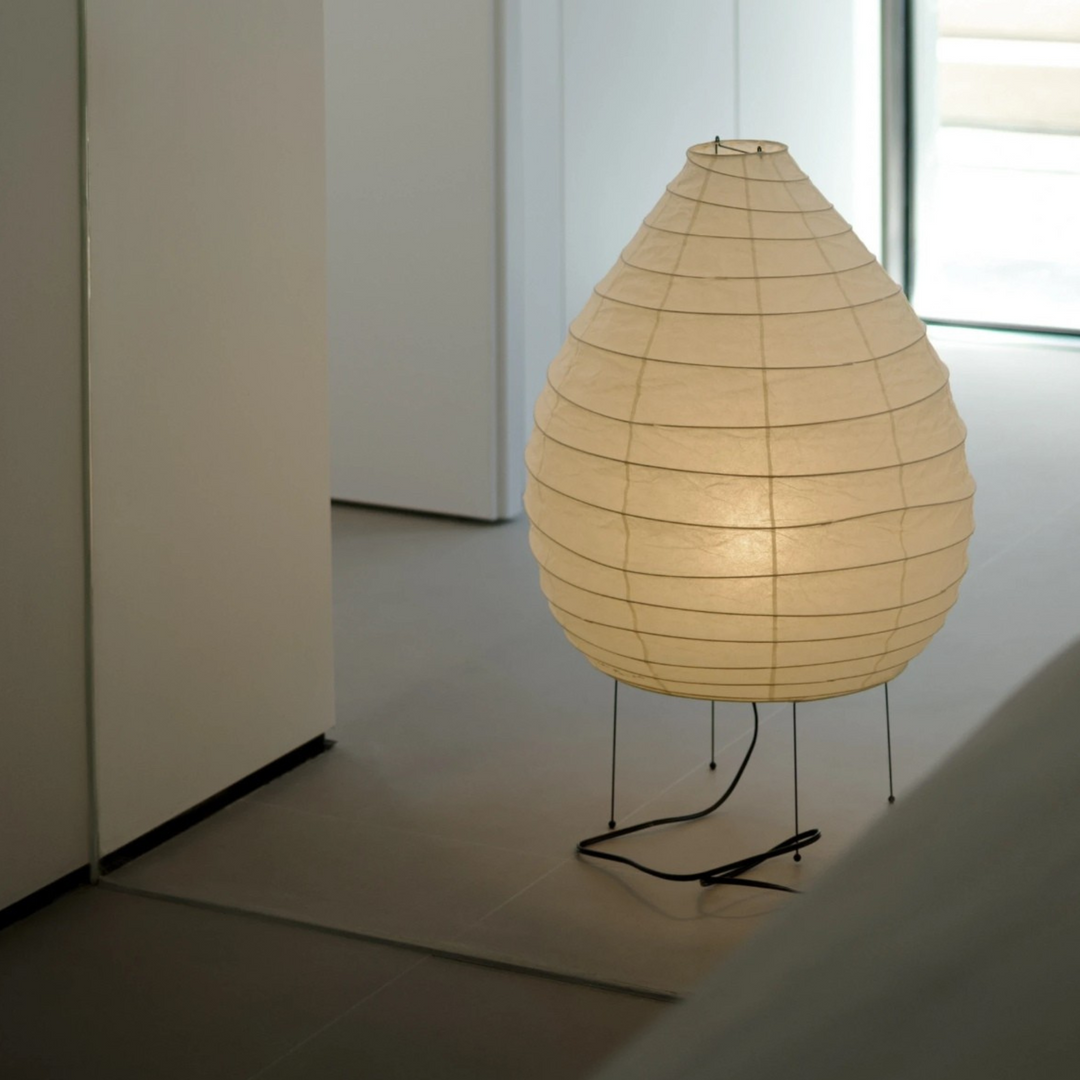 Wabi-Sabi style paper floor lamp softly lights a minimalist hallway with organic wall texture.