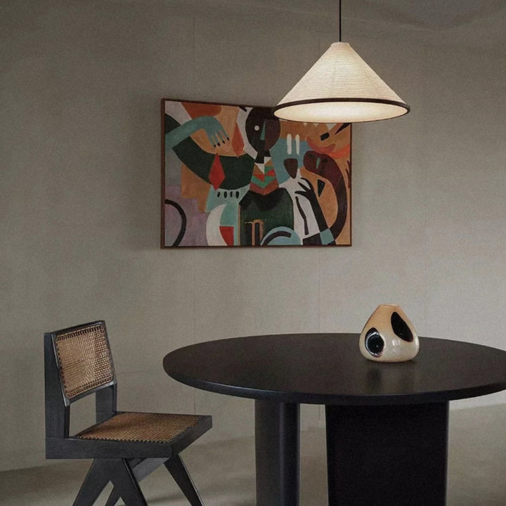 modern pendant light centered over a dining table with chairs.