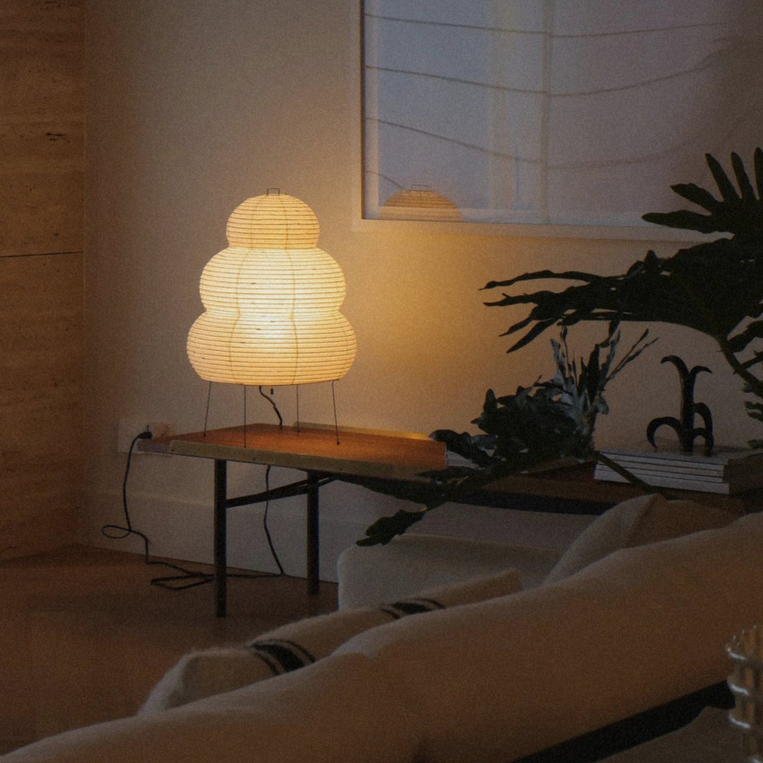 warm glow from a washi paper floor lamp fills a calm living room at night.