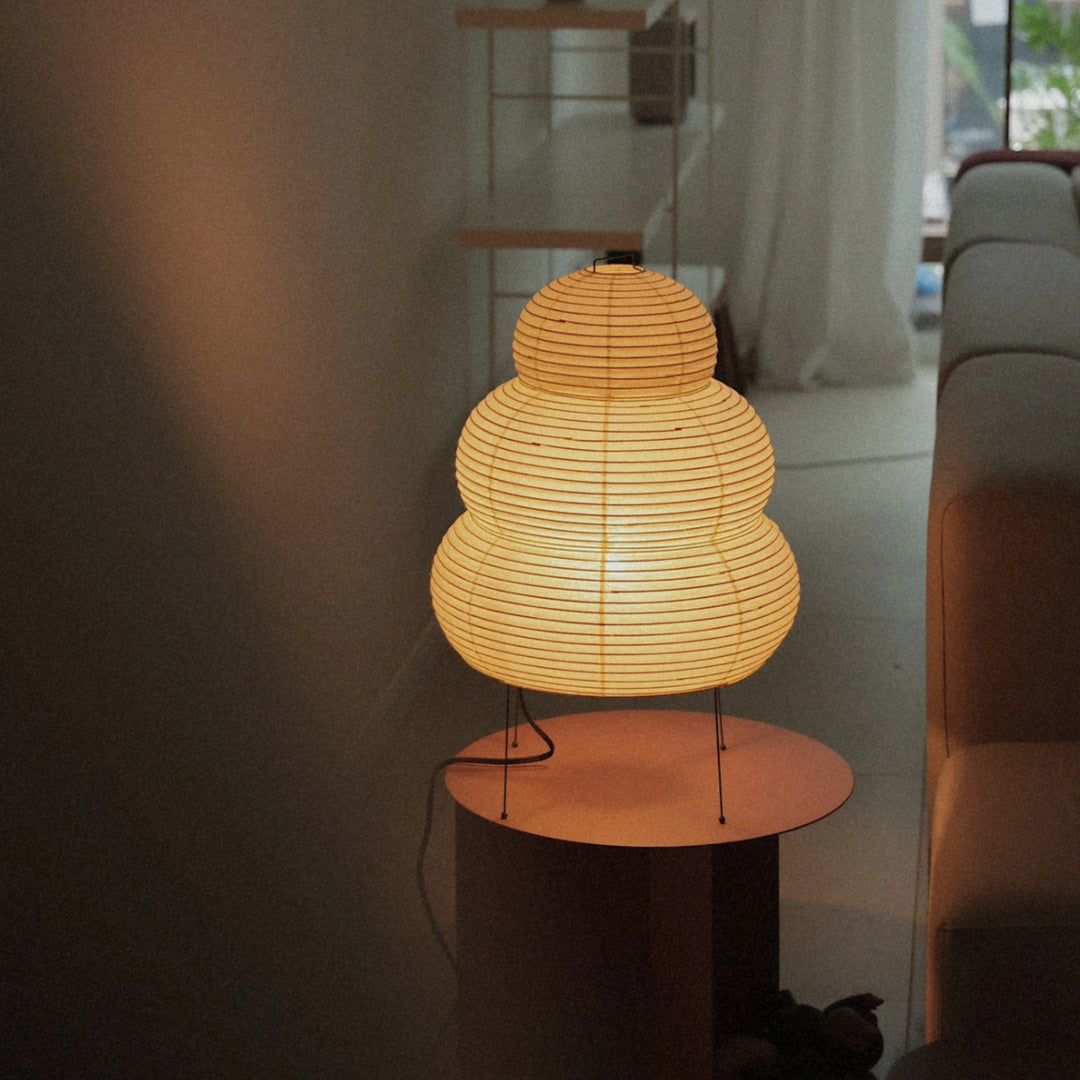 close view of a glowing washi paper floor lamp placed on a small table.