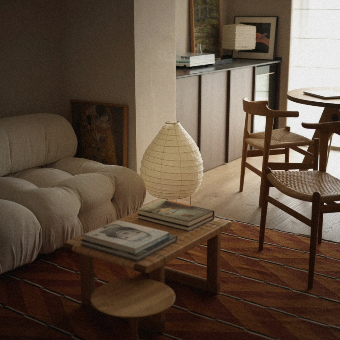 washi paper lantern floor lamp placed beside a sofa and coffee table adding soft diffused lighting to a modern living room.