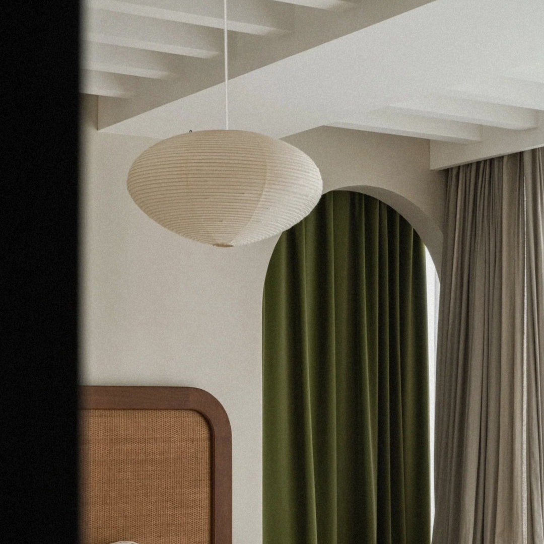 washi paper pendant light hanging from the ceiling above a softly lit interior corner.