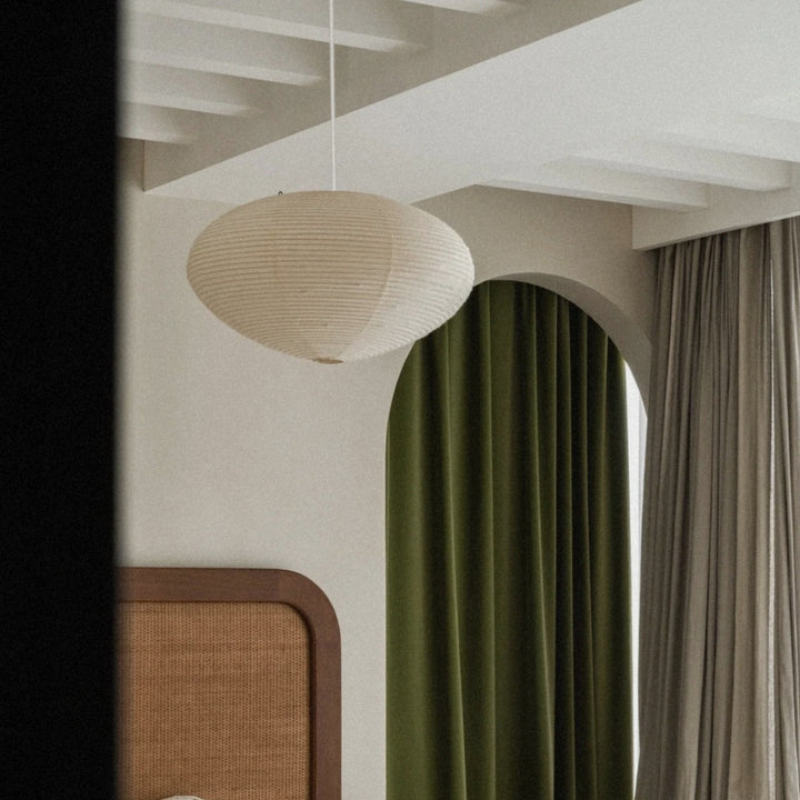 washi paper pendant light hanging from the ceiling above a softly lit interior corner.
