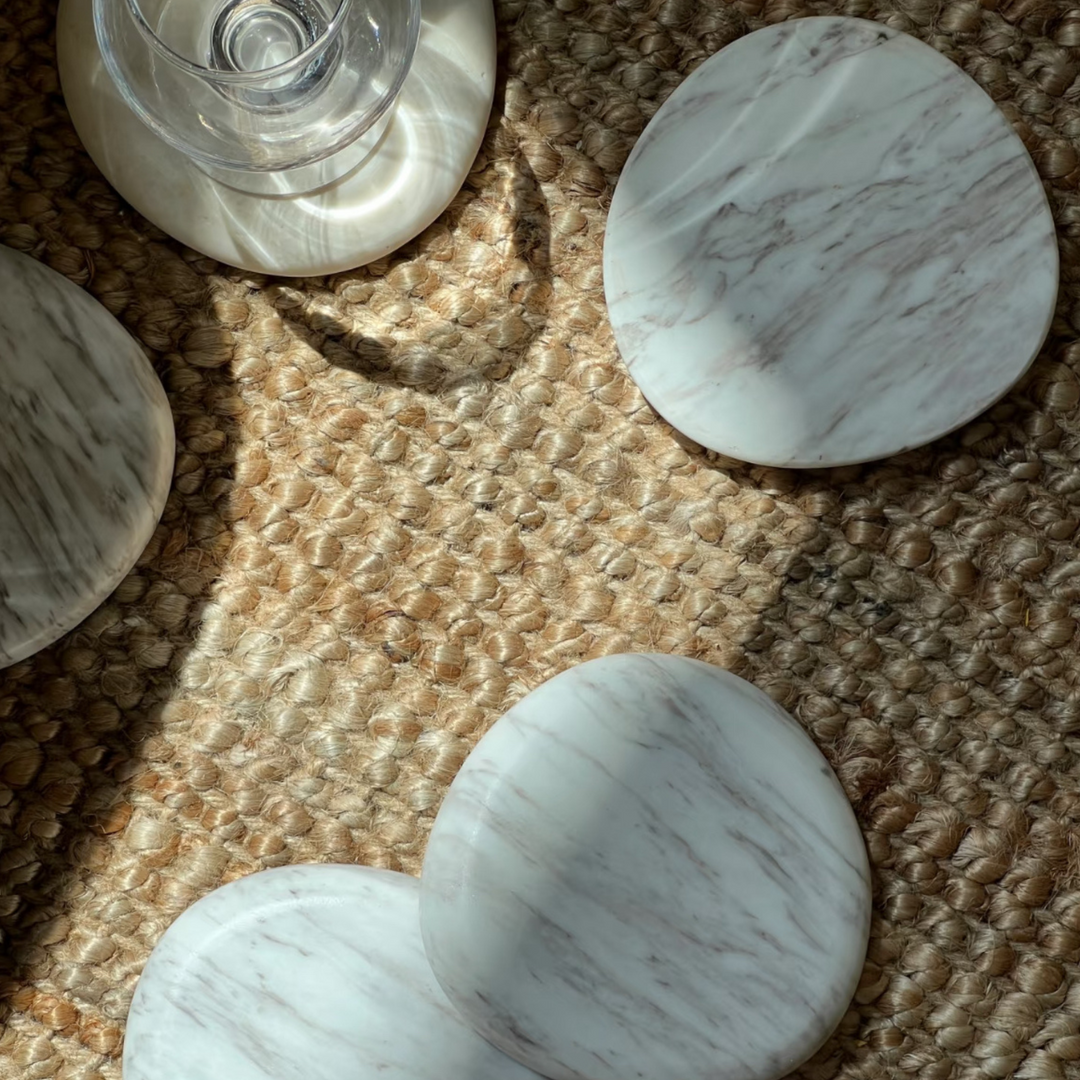 White marble coasters casting shadows in the morning light, offering a blend of rustic charm and sophistication.