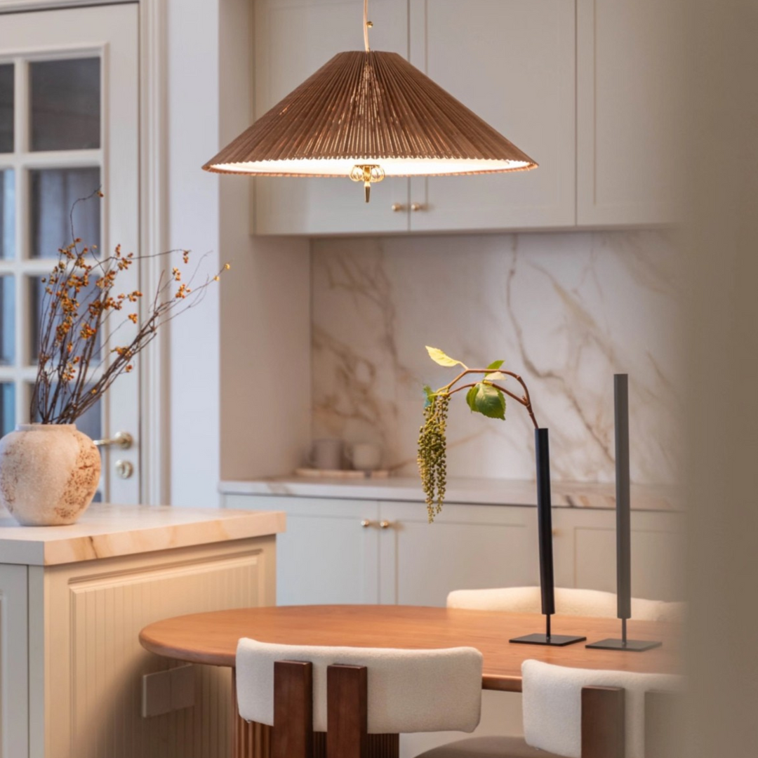 Handwoven ceiling lamp above a curved dining table with neutral tones