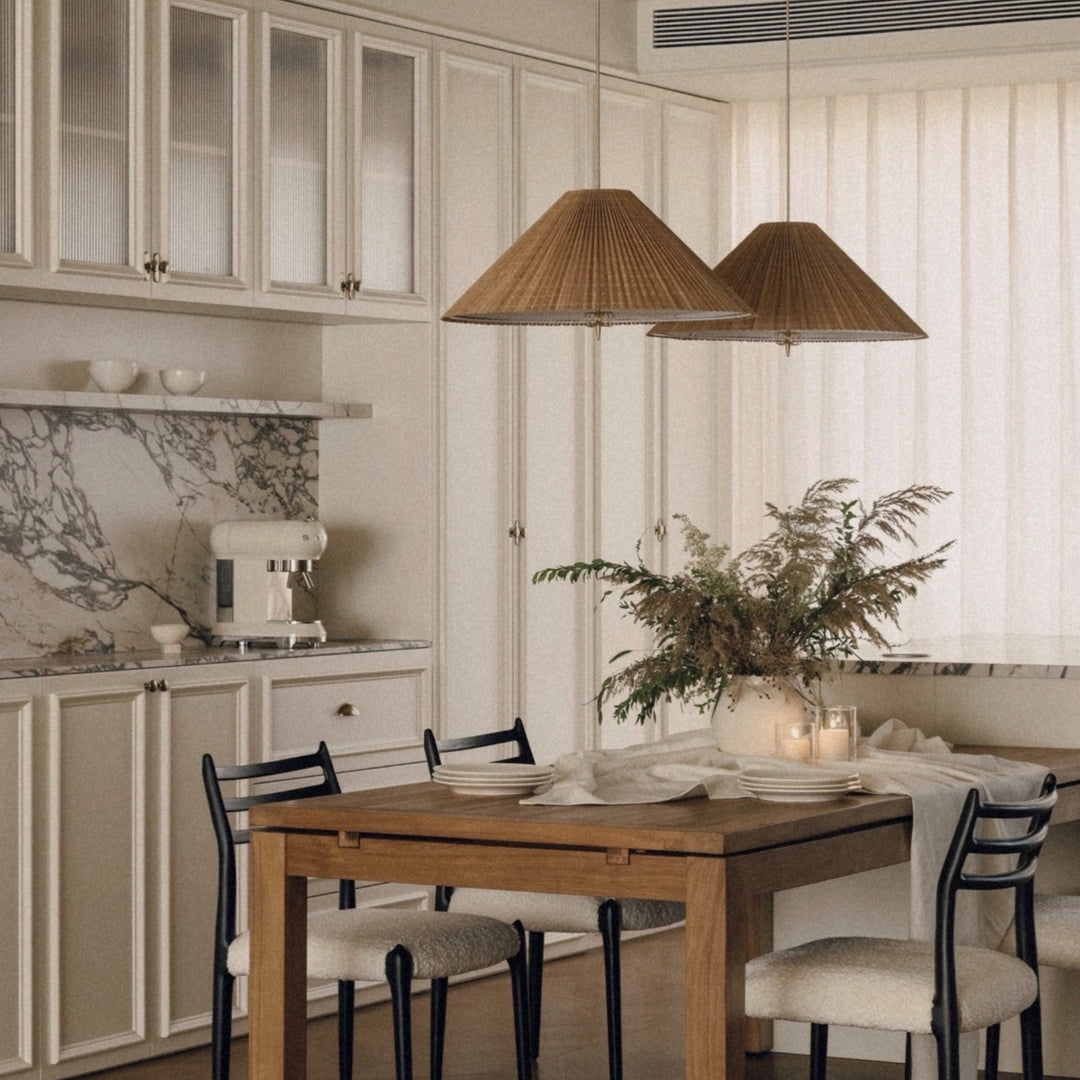 woven bamboo pendant light hanging above a wooden dining table in a bright natural dining room.